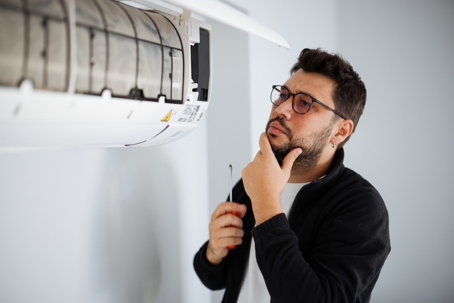 man trying to repair AC unit